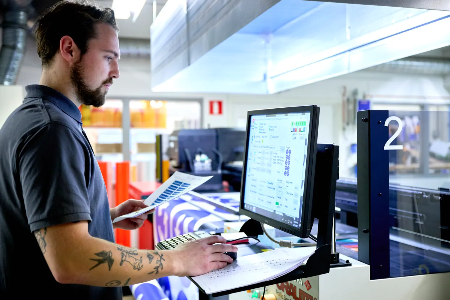 Grafiker på Blinkfyrars ritavdelning arbetar med en skyltritning vid datorn
